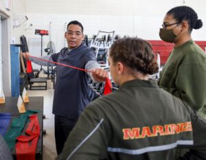 Scott Williams, an athletic trainer certified with the Smart Clinic, teaches a Marine proper form for his recovery exercise aboard Marine Corps Recruit Depot Parris Island, SC. (U.S. Marine Corps photo by Lance Cpl. Samuel C. Fletcher)